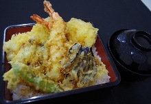 Tempura served over rice in a lacquered box