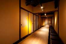 Japanese-style room Sunken kotatsu seating Fusuma sliding doors painted with seasonal scenes using traditional Japanese pigments Autumn-themed room