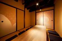 Japanese-style room Sunken kotatsu seating Fusuma sliding doors painted with seasonal scenes using traditional Japanese pigments Spring-themed room
