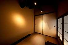 Japanese-style room Sunken kotatsu seating Fusuma sliding doors painted with seasonal scenes using traditional Japanese pigments Winter-themed room