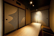 Japanese-style room Sunken kotatsu seating Fusuma sliding doors painted with seasonal scenes using traditional Japanese pigments Summer-themed room