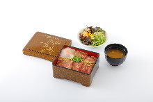 Roast beef served over rice in a lacquered box