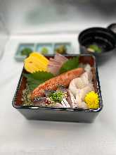 Seafood served over rice in a lacquered box