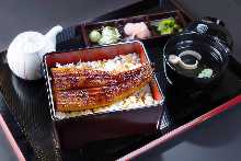 Regular eel served over rice in a lacquered box The size of the eel is half a tail