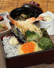 Whitebait and seafood tempura served over rice in a lacquered box