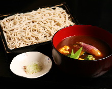 Chilled buckwheat soba noodles on a bamboo strainer with vegetables served