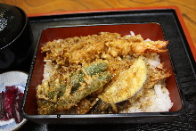 Tempura served over rice in a lacquered box