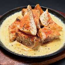 Grilled garlic toast with mentaiko cheese sauce on iron plate