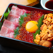 Seafood served over rice in a lacquered box