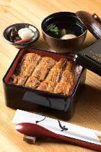 gold Eel served over rice in a lacquered box Three quarter eel