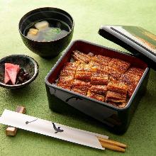 of gold Eel served over rice in a lacquered box One eel