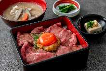 Roast beef served over rice in a lacquered box