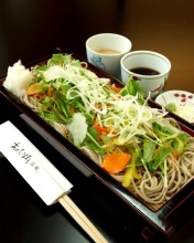 Chilled buckwheat soba noodles on a bamboo strainer with vegetables served