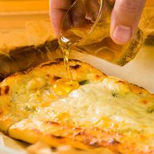 Three-Cheese naan pizza assortment with honey