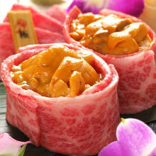 Meat-wrapped gunkan sushi rolls topped with sea urchin