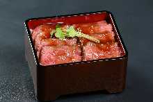 Roast beef served over rice in a lacquered box