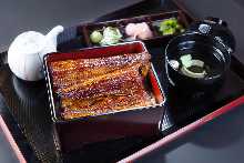 Delux eel served over rice in a lacquered box The size of the eel is a whole tail
